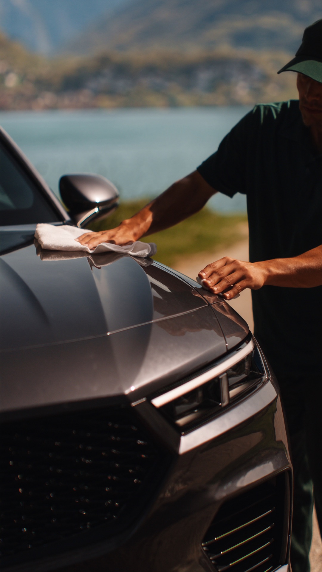 Dettaglio waterless a mano sul cofano di un SUV premium — lavaggio Wash Now sulle rive del lago di Lugano