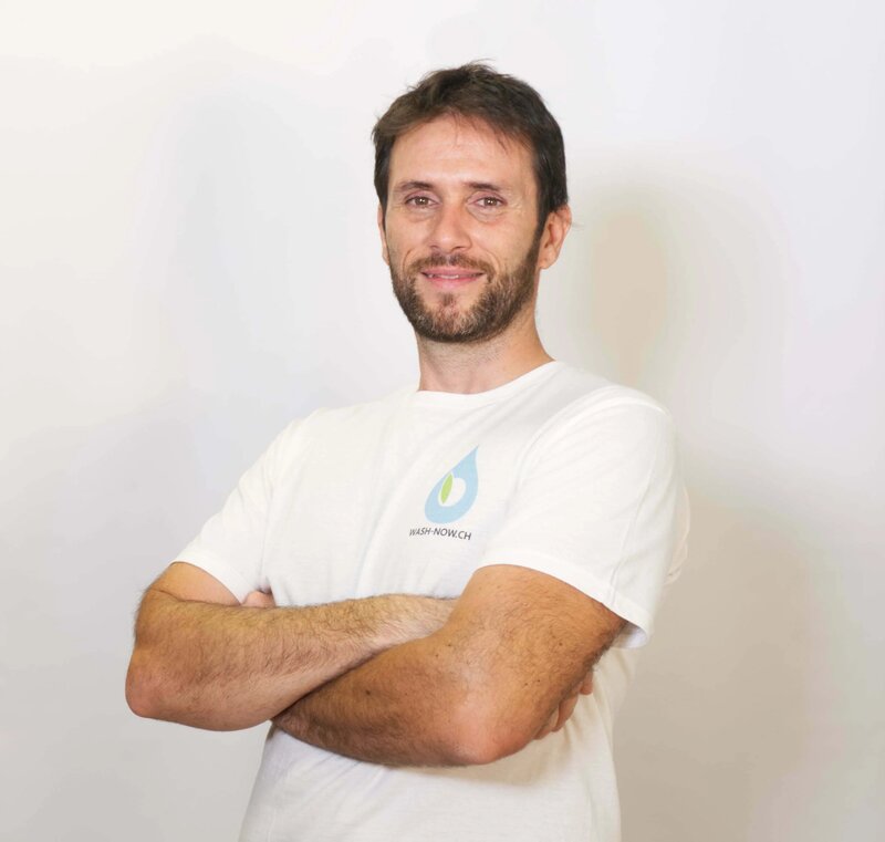 Sam, fondatore di Wash Now, in t-shirt brand a braccia conserte