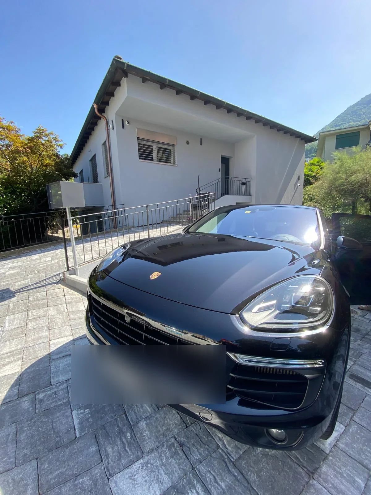 Porsche Cayenne nera lucida davanti a una villa di Massagno